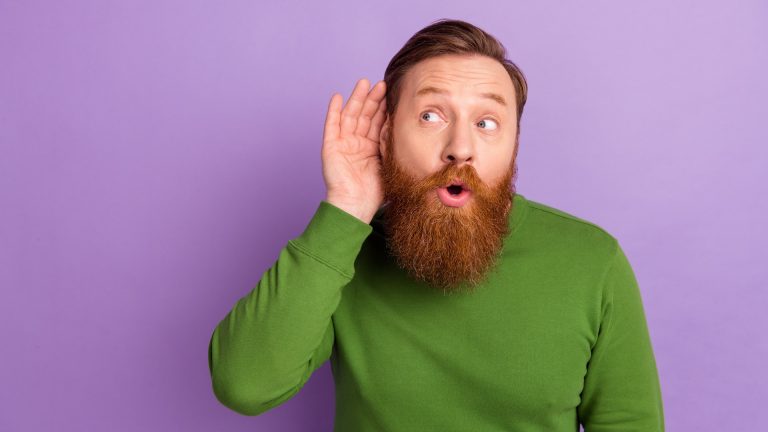 Portrait of attractive curious funny guy listening info copy space advert sale isolated over bright violet lilac color background